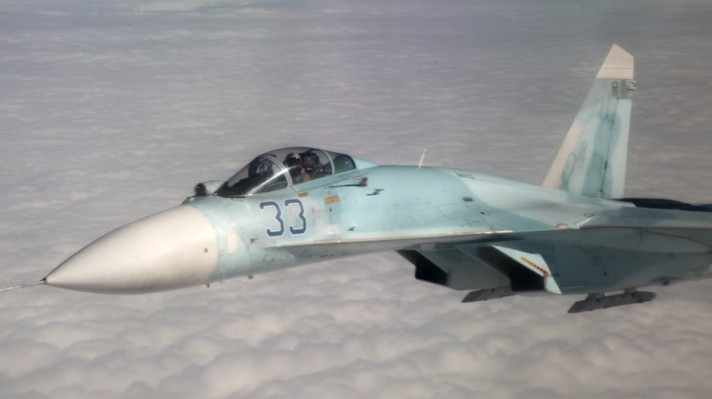 
Російський винищувач Су-27 летить над скупченням хмар.